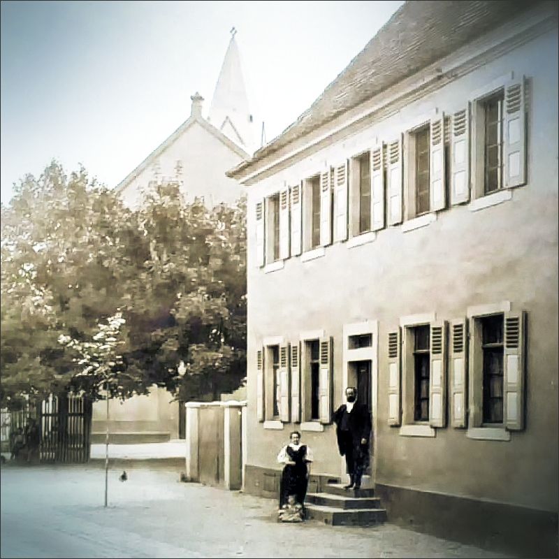 Das 1784 eingeweihte Altriper Pfarrhaus in einer Aufnahme vom Ende des 19. Jahrhunderts. Im Eingang steht Pfarrer Horst Buchholz, der 1894 die jetzige Kirche einweihte.
