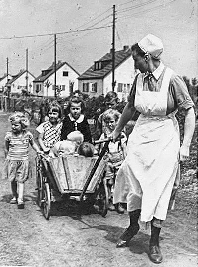 Schwester der Nationalsozialistischen Volkswohlfahrt (NSV) mit Kindern bei einem Ausflug 1943 (Quelle: Bundesarchiv)
