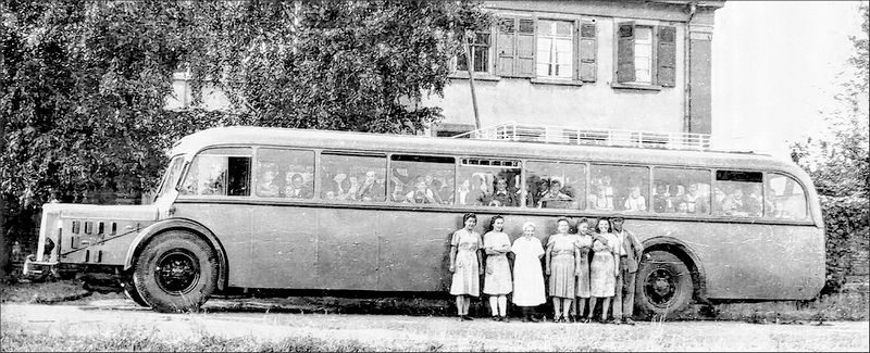 Mit dem Bus werden die Kinder nach Altrip und wieder nach Hause gebracht. In der Mitte vor dem Bus (ganz in weiß) steht „Tante Hilde“.